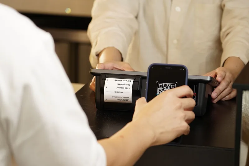 Person scanning a QR code to complete a PayNow mobile payment