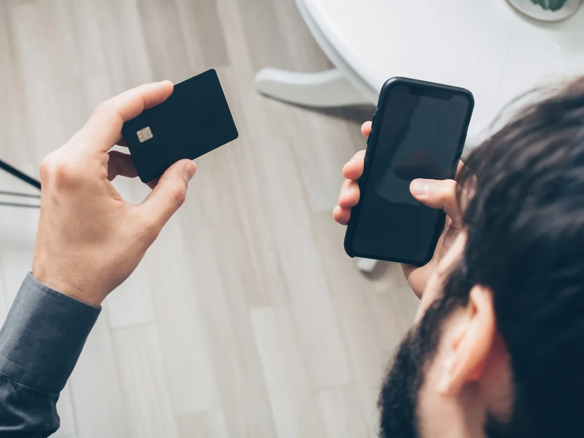 Man using smartphone and credit card for online shopping to pay in installments